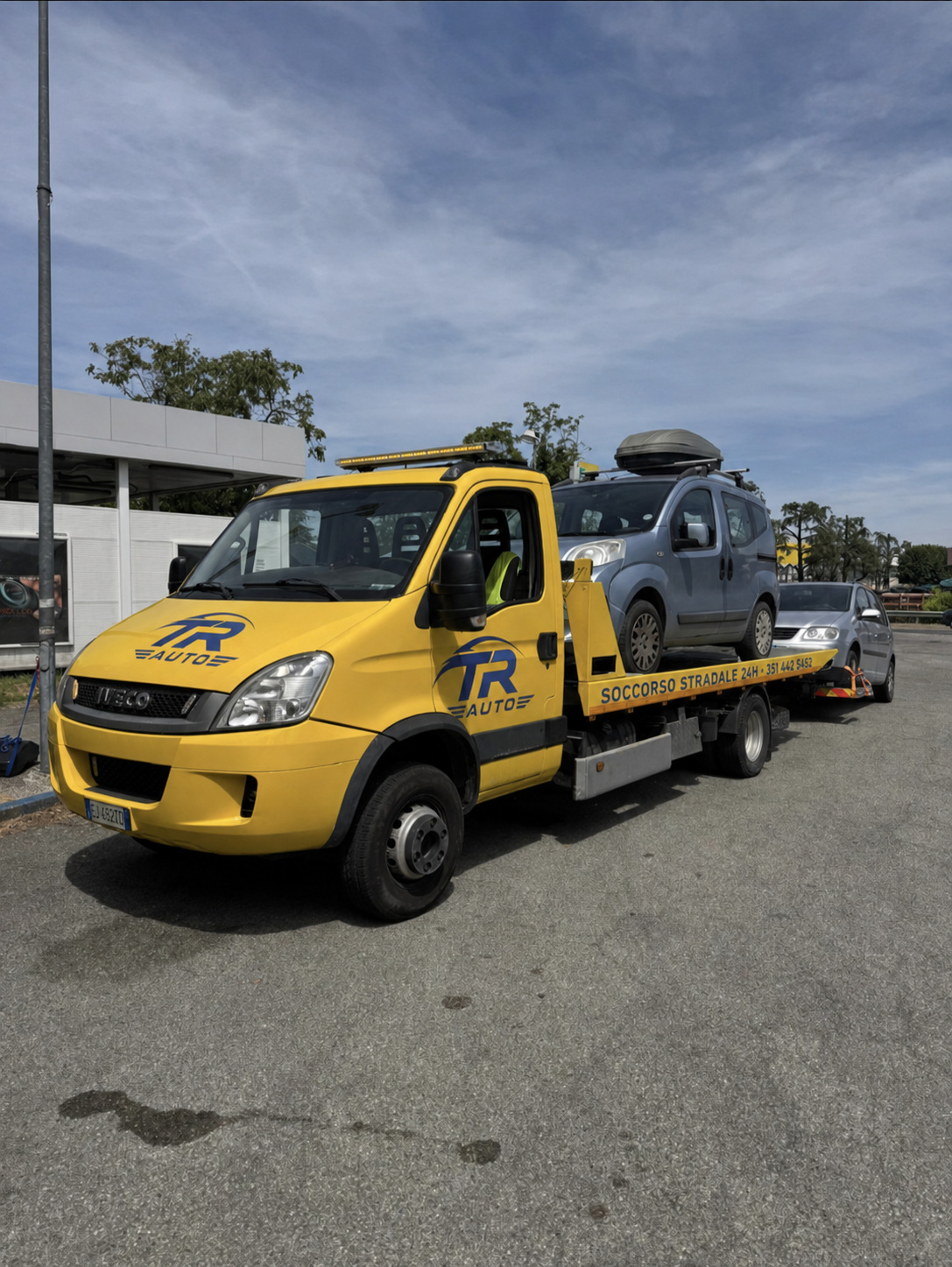 Carroattrezzi giallo TR Auto con veicolo caricato, logo sul cofano e numero di soccorso stradale
